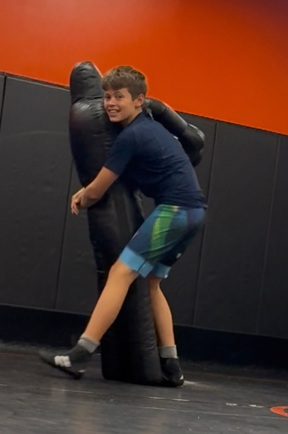 Matthew practicing wrestling throws on a grappling dummy